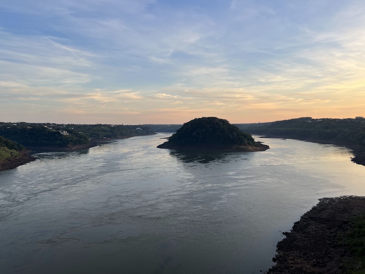 Atardecer sobre el río con una isla y vegetación en silueta